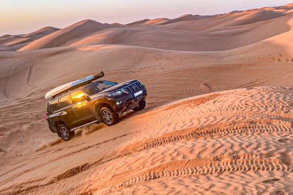 Offroad car driving up the sand dune in Sahara desert