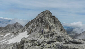 high altitude saddle with a sharp peak surrounding it. Small snow field on the side of the mountain