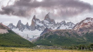 El Chalten Circuit sharp spiky mountains above the yellow pampa and glacier below surrounded by brown clouds