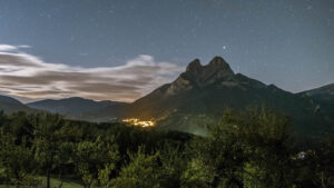 Pedraforca-1 Sharp pitchfork stone moholith standing high iat night with the small village below