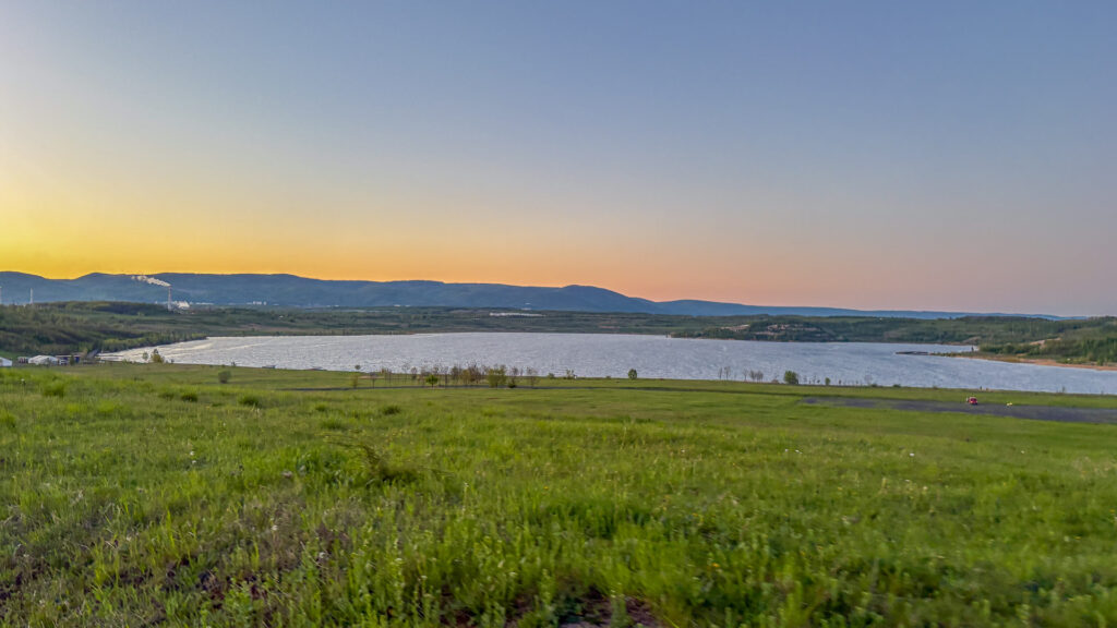 nice lake with a green grass around while sunset
