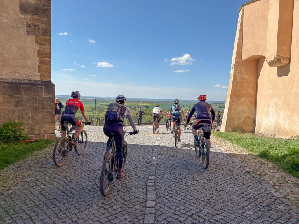 bunch of cyclist riding thru the town of Mělník