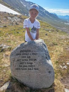 Girl in Swedish tundra near the stone with runes