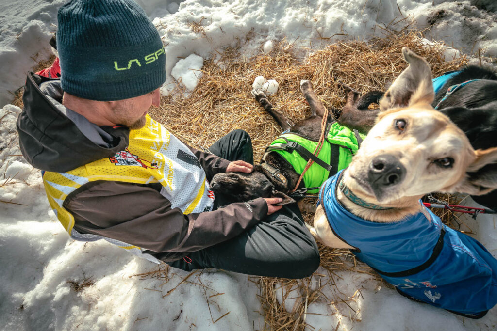 Musher sitting with his dog at the Bivac