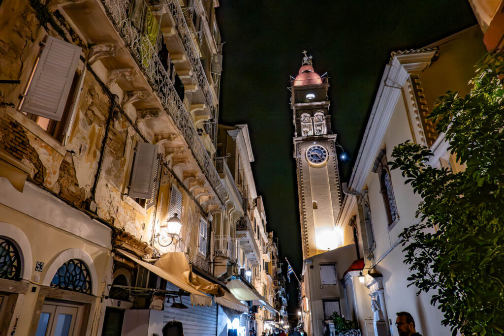 a church tower in the middle of the old greek town's aisles