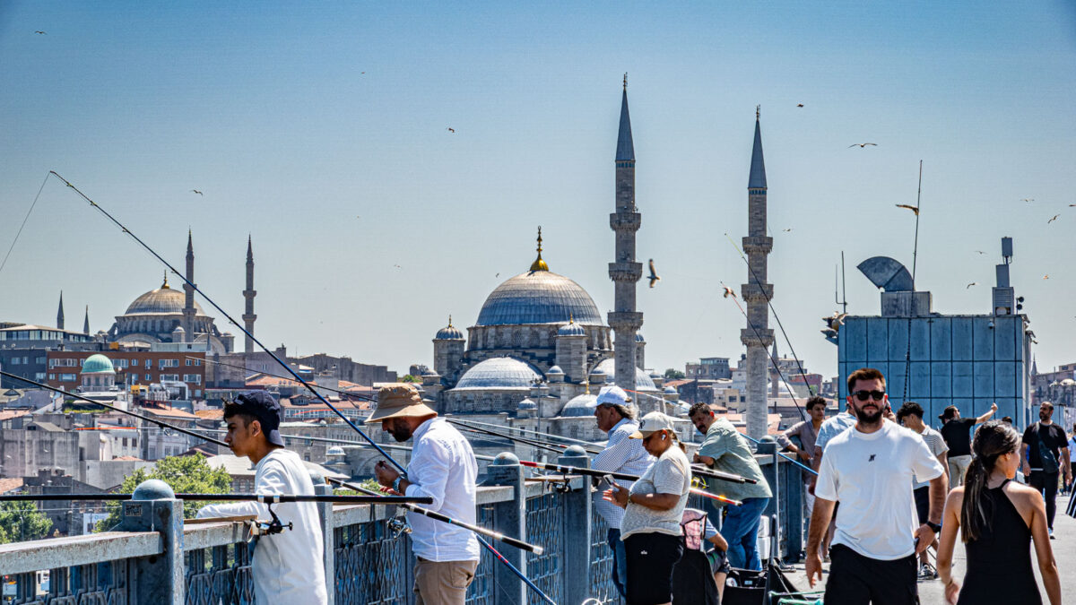 Fishermen in the bridge in ostanbul with mosque behing them