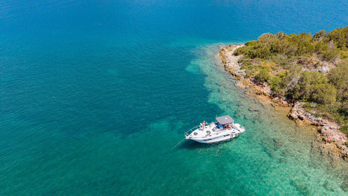 Small boat moored at the Trizonia island with shoreline